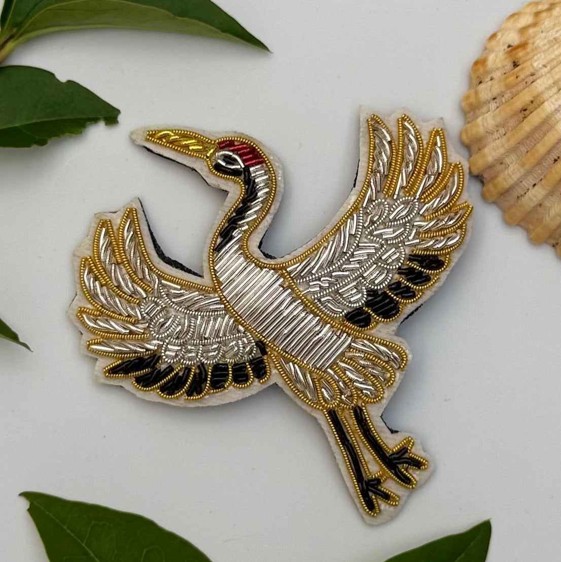 Broche grue brodée main – bijou artisanal grue oiseau Japon élégance longévité origami perles et fils blancs rouges – Tawus
