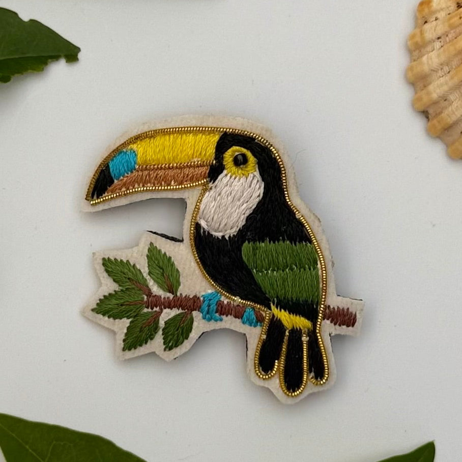 Broche toucan brodée main – bijou artisanal toucan oiseau tropical Amazonie bec coloré perles et fils jaunes orangés noirs – Tawus

