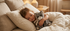Un enfant endormi dans son lit serre contre lui la peluche chat gris Kitty de Bukowski Design, avec son écharpe écrue