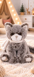 Peluche chat gris Kitty de Bukowski Design assise sur un tapis dans une chambre, avec un museau blanc et une écharpe écrue.