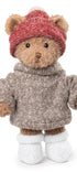 Peluche ours Matt de Bukowski Design vue de face sur fond blanc, en pull gris, bonnet rouge et chaussons blancs