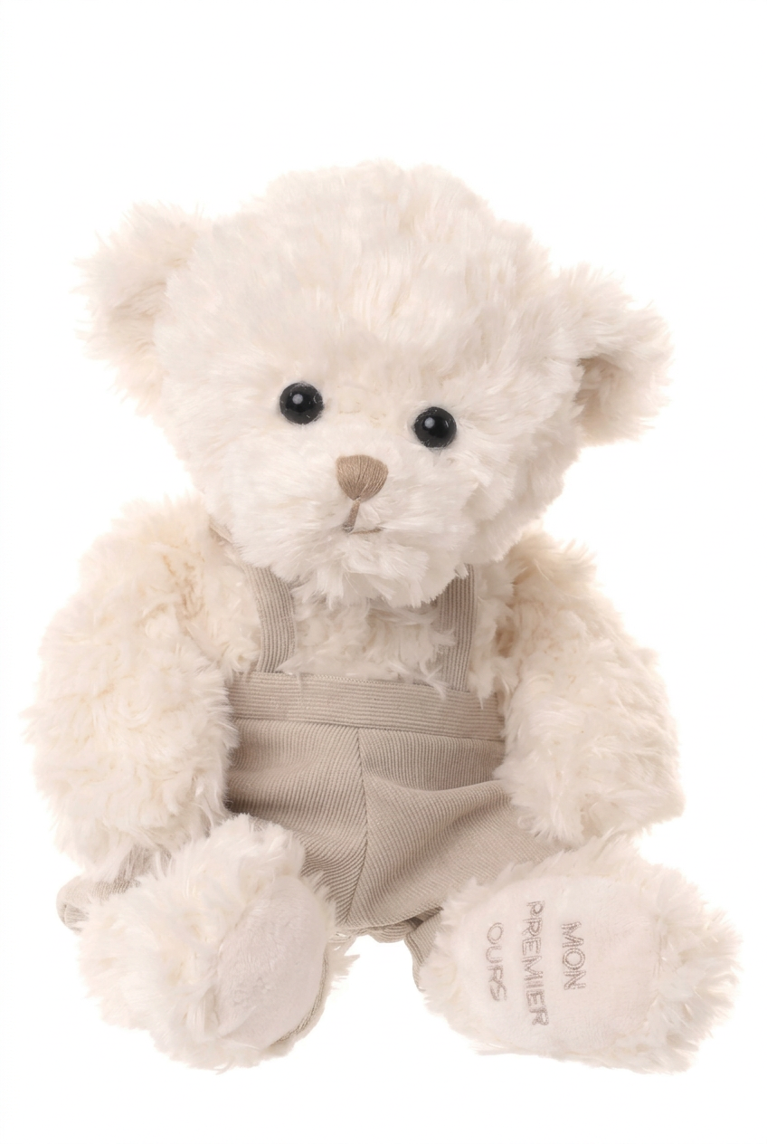 Peluche ours écru Wyatt de Bukowski Design sur fond blanc, en salopette beige, avec l’inscription Mon premier ours brodée sous une patte