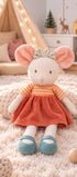 Peluche souris Ingefrid de Bukowski Design assise sur un tapis, avec une jupe corail, un nœud fleuri et des chaussures bleues