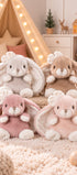  Quatre peluches lapin Cute Kanina de Bukowski Design, en gris clair, taupe, rose et vieux rose, réunies sur un tapis dans une chambre