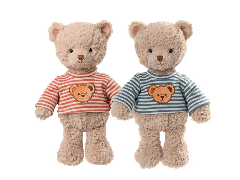  Deux peluches ours Colin de Bukowski Design côte à côte, l’une en haut rayé rouge et blanc, l’autre en haut rayé bleu-vert et blanc.